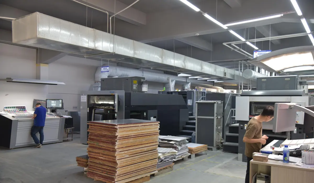 Playing card printing production floor with press operators and paper sheets